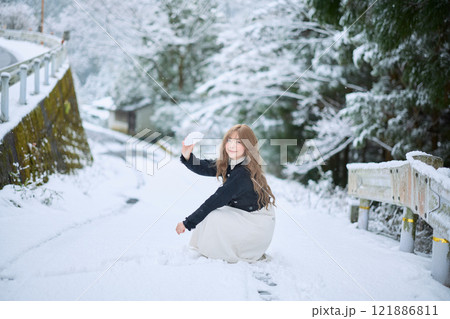 雪の中で散歩する女性 121886811