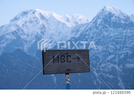 A wood sign lead to Machapuchare base camp in Nepal with view of Mt.Annapurna South (7,219 m) and Mt.Hiunchuli (6,441 m) in the background. A wood sign lead to Machapuchare base camp in Nepal with view of Mt.Annapurna South (7,219 m) and Mt.Hiunchuli (6,441 m) in the background. 121888390