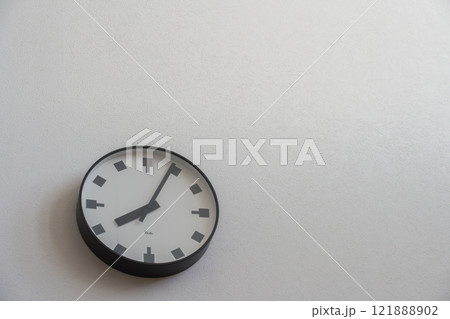 白い壁に掛かった壁掛け時計 121888902