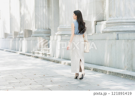 オフィス街の木陰を歩くビジネスウーマン 後ろ姿 121891419