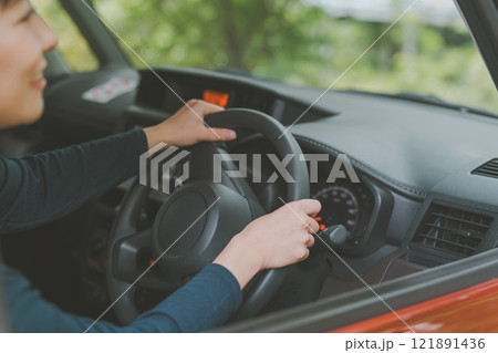 車のハンドルを握る女性 121891436