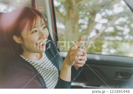 スマホ地図アプリでルート検索する助手席の女性 スマホ地図アプリでルート検索する助手席の女性 121891448