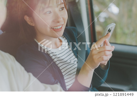 スマホ地図アプリでルート検索する助手席の女性 スマホ地図アプリでルート検索する助手席の女性 121891449