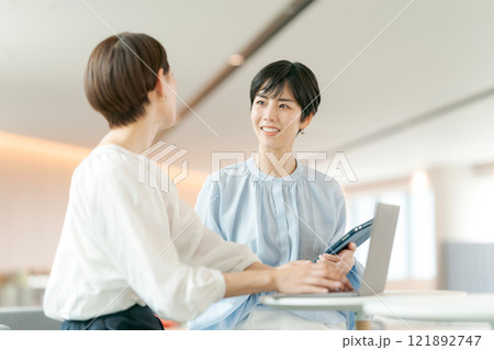 笑顔で打ち合わせをする女性 121892747
