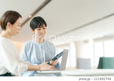 笑顔で打ち合わせをする女性 121892748