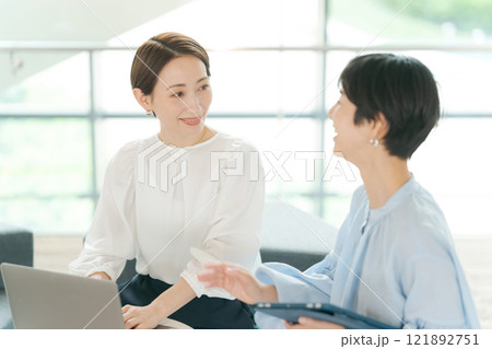 笑顔で打ち合わせをする女性 121892751