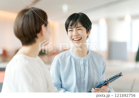 笑顔で打ち合わせをする女性 121892756
