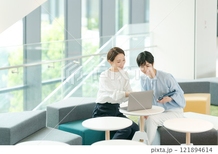 オープンスペースで打ち合わせをする女性 121894614