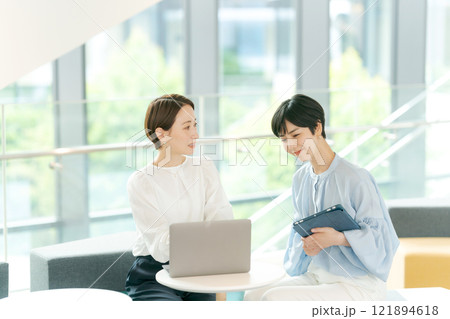 オープンスペースで打ち合わせをする女性 オープンスペースで打ち合わせをする女性 121894618