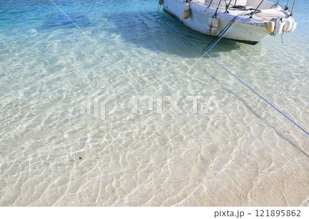 晴れた日の白い砂浜と青い海に浮かぶ船 晴れた日の白い砂浜と青い海に浮かぶ船 121895862