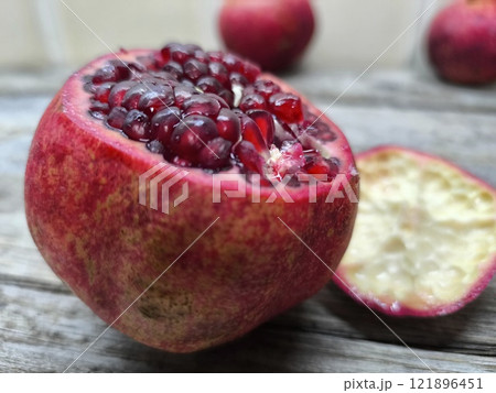 Sweet red pomegranate on a wooden table. 121896451