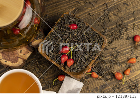 red rosehip fruits and hot green tea in a transparent teapot red rosehip fruits and hot green tea in a transparent teapot 121897115