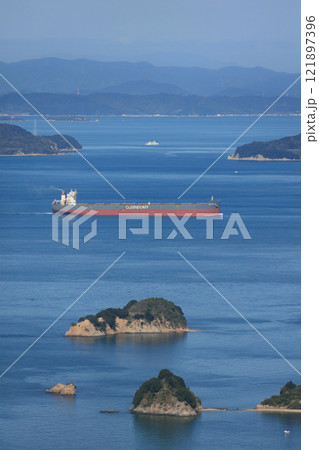 高松沖の備讃瀬戸、手前が大島、貨物船の奥の右が小豊島左が豊島、遠景は岡山県の牛窓付近 121897396