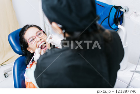 Top view of dentist doing dental checkup, patient checked by dentist, close up of dentist with patient, dentist doing root canal treatment on patient 121897740