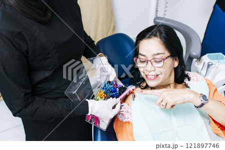 Patient with dentist choosing dental braces, Dentist with patient choosing metal braces, Patient with dentist choosing rubber band 121897746