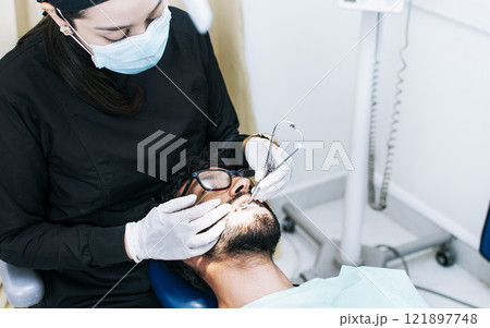 Dentist checking braces to patient, patient checked by dentist, Dentist performing dental checkup 121897748