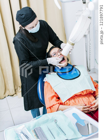 Female dentist doing dental x-ray, Female dentist doing x-ray to patient, female dentist doing dental x-ray, dental x-ray concept Female dentist doing dental x-ray, Female dentist doing x-ray to patient, female dentist doing dental x-ray, dental x-ray concept 121897791