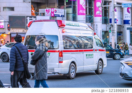 日本の東京都市景観　サイレンを鳴らし「末広町駅」前「外神田五丁目」の交差点を通過する救急車 121898933