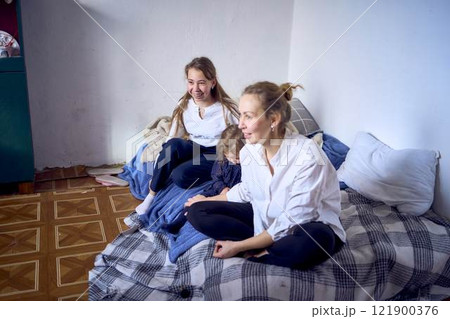 family with toddler and teenager playing games, laughing, clapping and celebrating a small family party 121900376