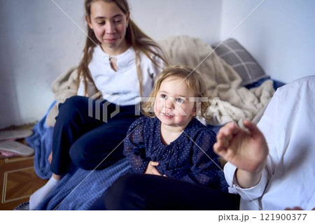family with toddler and teenager playing games, laughing, clapping and celebrating a small family party family with toddler and teenager playing games, laughing, clapping and celebrating a small family party 121900377