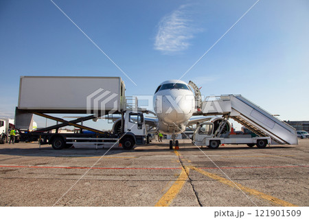 Boarding passengers on the plane. Boarding bridge. The plane lands at the international airport. Loading luggage. White airplane. Terminal Runway. Copy space Boarding passengers on the plane. Boarding bridge. The plane lands at the international airport. Loading luggage. White airplane. Terminal Runway. Copy space 121901509