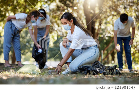 Group of volunteers picking up, cleaning and reducing pollution in a public nature park together. Diverse community wearing face masks to protect from disease, collecting dirt and doing cleanup Group of volunteers picking up, cleaning and reducing pollution in a public nature park together. Diverse community wearing face masks to protect from disease, collecting dirt and doing cleanup 121901547