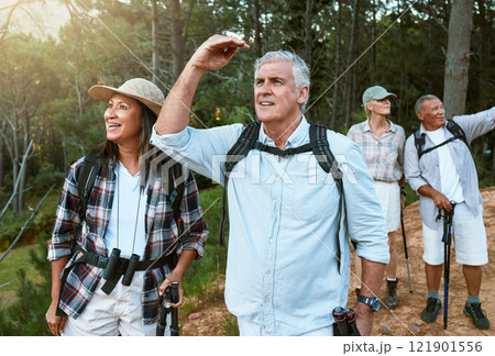 Hiking, adventure and exploring with a group of senior friends having fun, exercising and enjoying the outdoors. Walking, discovery and journey with old people sightseeing in the forest or woods 121901556