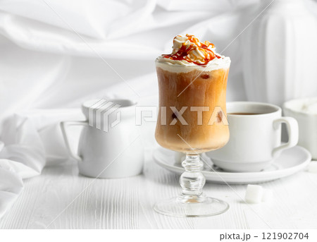 Iced caramel latte topped with whipped cream and caramel sauce. Iced caramel latte topped with whipped cream and caramel sauce. 121902704