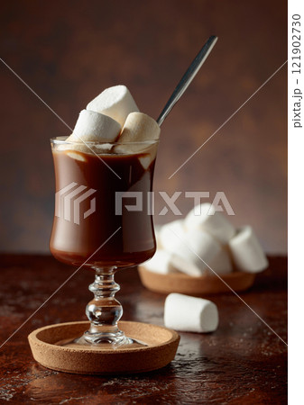 Hot chocolate with marshmallows in a glass mug on a old brown table. 121902730