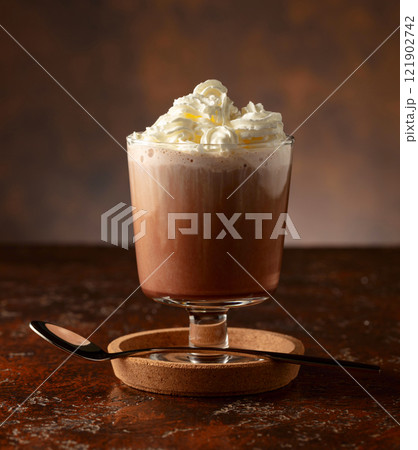 Hot chocolate with whipped cream in a glass mug. 121902742