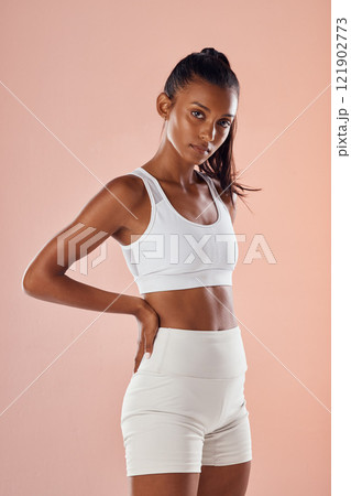 Wellness, health and fitness with a tough woman looking sporty and feeling confident against a pink background. Portrait of a motivated, slim, proud athlete satisfied with her physical and body goals Wellness, health and fitness with a tough woman looking sporty and feeling confident against a pink background. Portrait of a motivated, slim, proud athlete satisfied with her physical and body goals 121902773