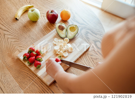 Health, diet and healthy woman cutting fruit to make a smoothie with nutrition for an organic meal at home. Closeup of caucasian female hands chopping fresh produce for a health in a kitchen. Health, diet and healthy woman cutting fruit to make a smoothie with nutrition for an organic meal at home. Closeup of caucasian female hands chopping fresh produce for a health in a kitchen. 121902819