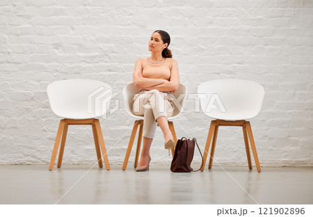 Employment, hiring and recruitment with a young business woman sitting on a chair waiting for her interview with human resources. Female shortlist candidate looking impatient or nervous for a meeting 121902896