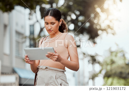 Reading, checking or browsing social media on tablet while out commuting through city and looking for directions or inspiration online. Young entrepreneur using business website tool for ideas 121903172