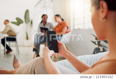 Businesswoman on a phone with blank screen copy for website, marketing or advertising app with colleagues in background. Corporate worker holding, showing space on cellphone in vibrant workplace Businesswoman on a phone with blank screen copy for website, marketing or advertising app with colleagues in background. Corporate worker holding, showing space on cellphone in vibrant workplace 121903182