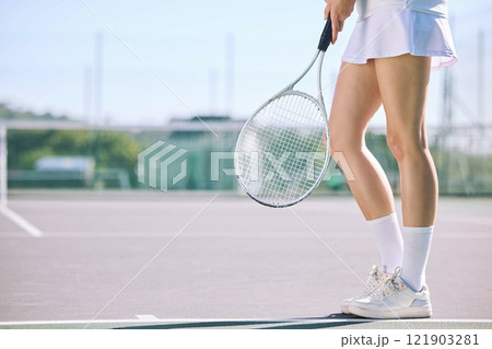 Legs of a female tennis player practicing or training for a match outdoors on the court on a sunny day. Active, fit and athletic female athlete or sportswoman playing a sport for a club 121903281