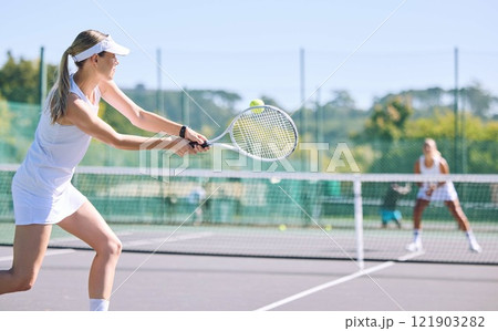 Sports and active tennis player hitting ball with racket equipment during a competitive match or hobby activity on a court. Athletic, sporty and fit woman playing in a tournament game with sportswear Sports and active tennis player hitting ball with racket equipment during a competitive match or hobby activity on a court. Athletic, sporty and fit woman playing in a tournament game with sportswear 121903282
