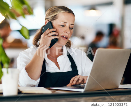Coffee shop owner on a phone call while working online on her laptop inside a local cafe store. Contact us, learn about us and talk to our baristas, managers and small startup business entrepreneurs Coffee shop owner on a phone call while working online on her laptop inside a local cafe store. Contact us, learn about us and talk to our baristas, managers and small startup business entrepreneurs 121903371