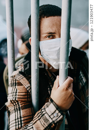 Sick, refugee of a young covid patient in quarantine to cross the border with a medical face mask. Foreign man in a prison crowd during a pandemic following healthcare safety rules of the virus. 121903477