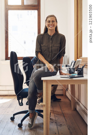 Creative startup entrepreneur and leader, motivation and inspiration for young females. Happy caucasian business woman and owner of consulting agency you can trust, sitting and smiling on work desk. 121903500