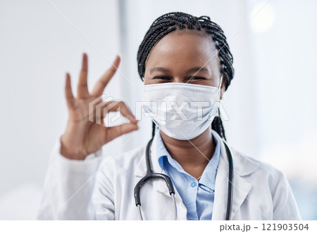 Doctor gesturing okay hand sign, symbol and emoji to express success and agreement in a good clinic or hospital. Portrait of a smiling medical pathologist looking happy after finding a cure for covid Doctor gesturing okay hand sign, symbol and emoji to express success and agreement in a good clinic or hospital. Portrait of a smiling medical pathologist looking happy after finding a cure for covid 121903504