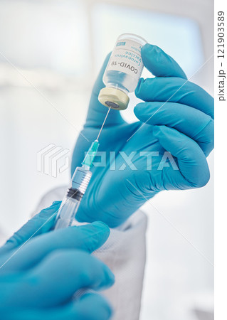 Medical doctor holding covid vaccine, giving injection during checkup and preparing needle for consultation. Closeup of the hands of a healthcare worker, expert or professional working at hospital Medical doctor holding covid vaccine, giving injection during checkup and preparing needle for consultation. Closeup of the hands of a healthcare worker, expert or professional working at hospital 121903589