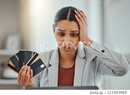 Finance, debt and credit with a business woman suffering from worry, stress and anxiety of inflation in the economy. Young female holding bank cards and having problems while trying to pay an account 121903669