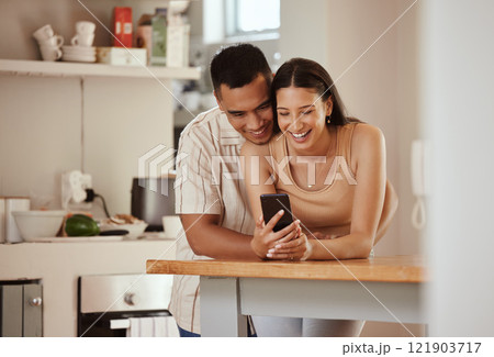 Happy, in love couple with a phone looking at funny content on social media, watching video or staying connected online. Bonding, romantic man and woman in relationship enjoying time together at home 121903717