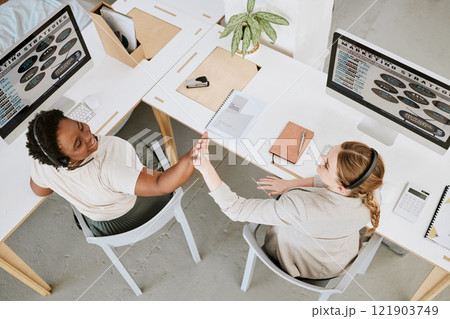 Teamwork, call center and high five between colleagues while celebrating a sale, reaching target or success at desks from above. Telemarketing agents or operators offering support and good service Teamwork, call center and high five between colleagues while celebrating a sale, reaching target or success at desks from above. Telemarketing agents or operators offering support and good service 121903749
