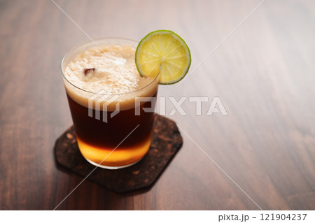 Espresso tonic in simple glass on walnut wood table with copy space 121904237