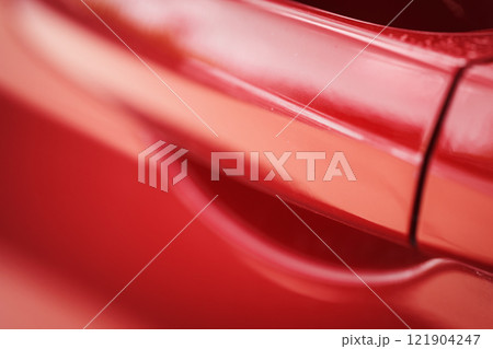 Closeup of red car with paint damage, long scratch 121904247