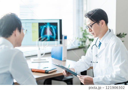 問診をするミドルの男性医師 121906302