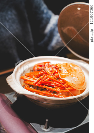 カニ鍋の蓋を開ける若い女性【撮影協力・海鮮居酒屋 魚魯こ】 カニ鍋の蓋を開ける若い女性【撮影協力・海鮮居酒屋 魚魯こ】 121907366
