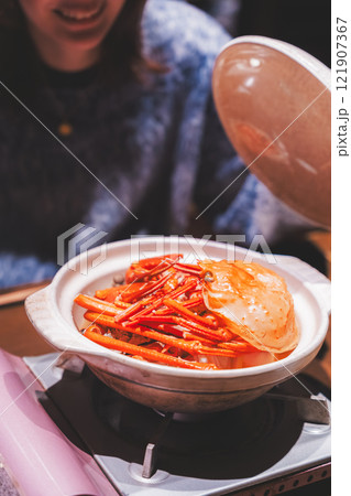 カニ鍋の蓋を開ける若い女性【撮影協力・海鮮居酒屋 魚魯こ】 カニ鍋の蓋を開ける若い女性【撮影協力・海鮮居酒屋 魚魯こ】 121907367